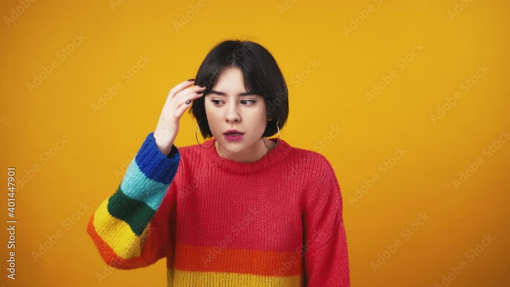 Young cute woman in red sweater with rainbow sleeves looking at camera with question and showing face palm gesture Young cute woman in red sweater with rainbow sleeves looking at camera with question and showing face palm gesture