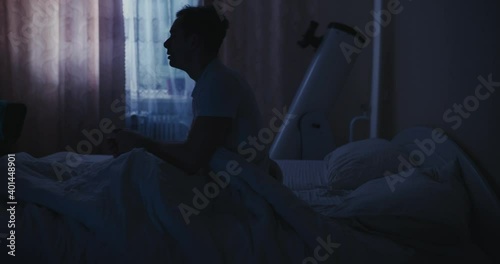 Bad sleep, man abruptly wake up in his bed at the night photo