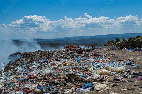 View of garbage field in trash dump or open landfill, food and plastic waste products polluting in a trash dump, Workers hands sorting garbage for recycling. © attraction art