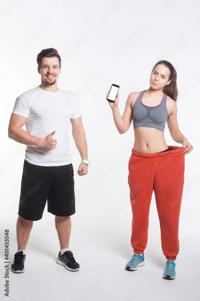 young male and female online workout with smart phone app isolated young male and female online workout with smart phone app isolated