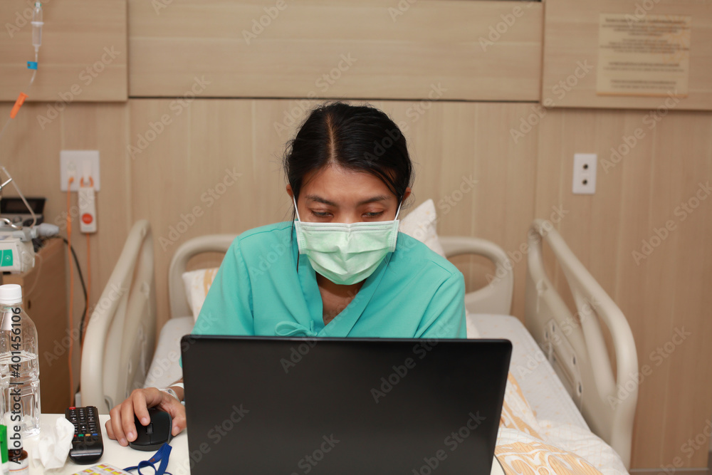 Femal patient work online by laptop on bed at hospital ward Femal patient work online by laptop on bed at hospital ward