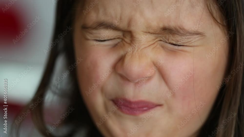 Little girl closing eyes squinting thinking and opening eyes looking at camera Little girl closing eyes squinting thinking and opening eyes looking at camera