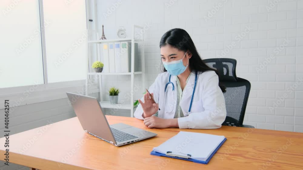 portrait Asian woman doctor talking online with patient, making video call, looking at camera, young female wearing white uniform with stethoscope speaking, consulting and therapy concept portrait Asian woman doctor talking online with patient, making video call, looking at camera, young female wearing white uniform with stethoscope speaking, consulting and therapy concept