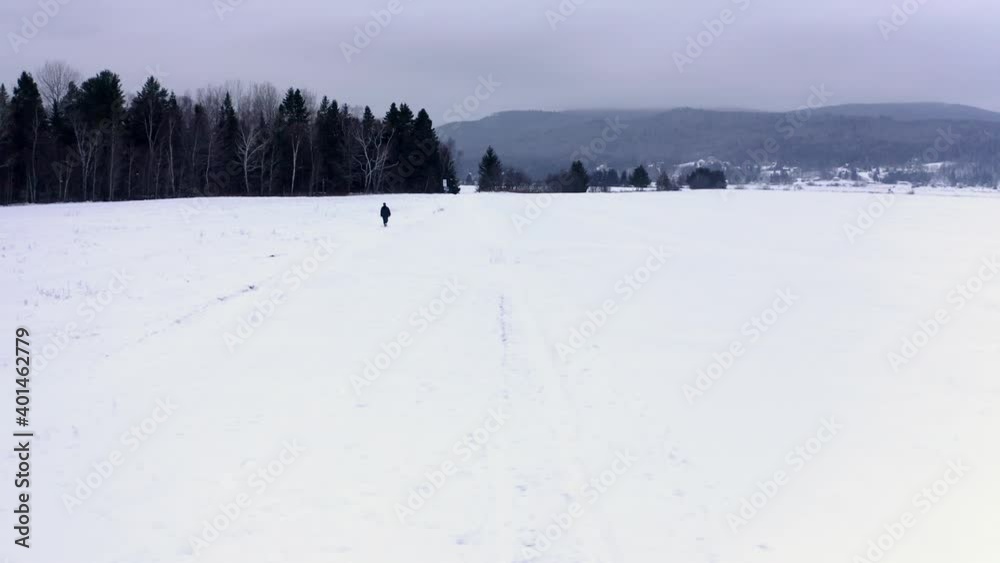 Lonely man walking on a small path in the snow in Charlevoix, Quebec Lonely man walking on a small path in the snow in Charlevoix, Quebec