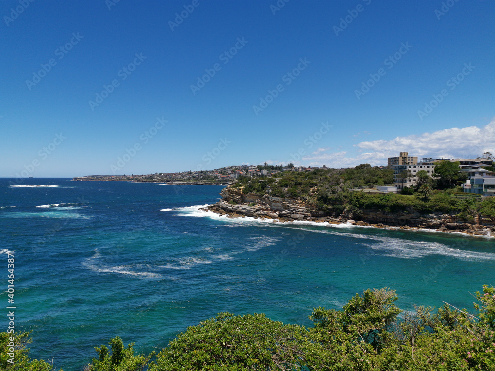 Stunning view of a deep blue sea and small beach from a coastal trail lookout, Sydney, New South Wales, Australia

