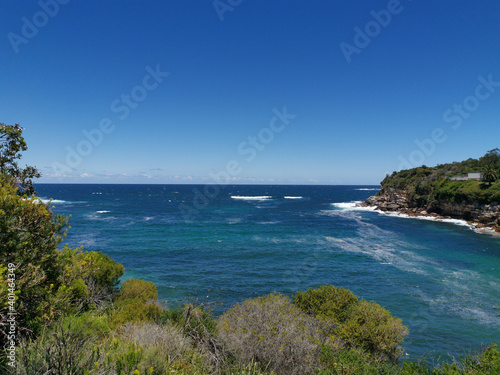 Fototapeta Naklejka Na Ścianę i Meble -  Stunning view of a deep blue sea and small beach from a coastal trail lookout, Sydney, New South Wales, Australia
