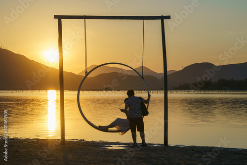Romantic swing by the lake at sunset