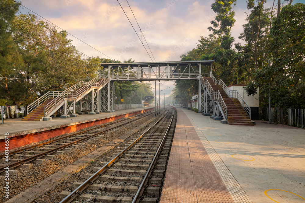 Fototapeta premium Empty railway station with train tracks with morning haze at sunrise at Kolkata India
