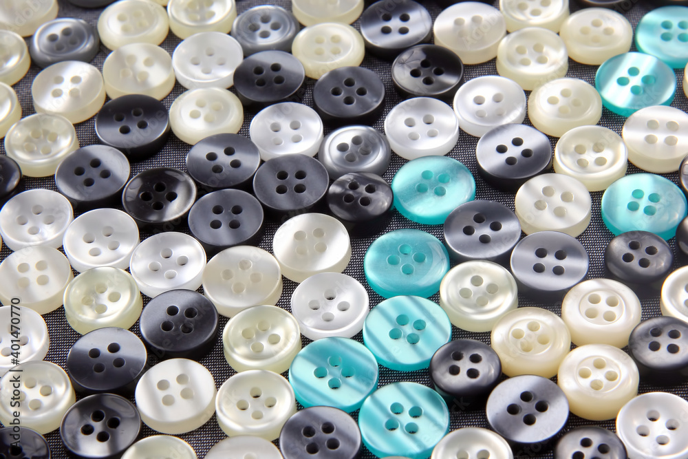 Plastic shiny buttons for clothes on a fabric background. Fashion and clothing. Factory industry Plastic shiny buttons for clothes on a fabric background. Fashion and clothing. Factory industry