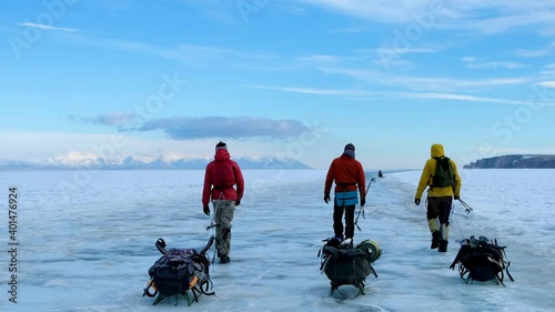 Skaters with sledges and backpacks on ice Lake Baikal in winter. photo