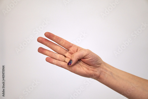 Give four. Right palm Caucasian female hand shows fingers and the thumb is bent. Hand brush on a white background.