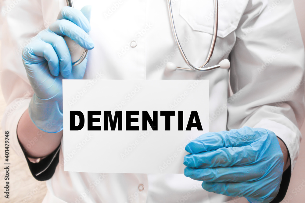The doctor's blue - gloved hands show the word DEMENTIA - . a gloved hand on a white background. Medical concept. the medicine The doctor's blue - gloved hands show the word DEMENTIA - . a gloved hand on a white background. Medical concept. the medicine