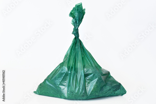 A close up image of large green dog poop bags on a white background.  photo