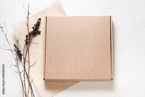 Brown cardboard box, minimalism style decorated with dried brunches