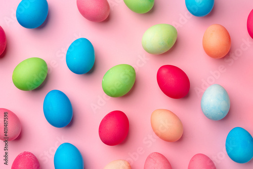 Painted Easter eggs on pink background top view