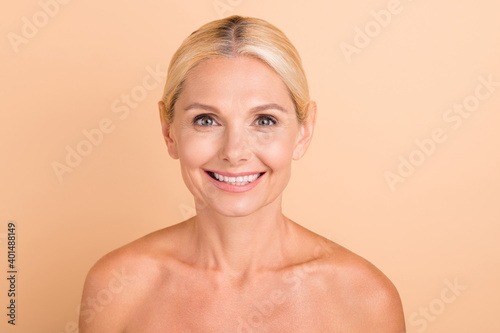 Photo of attractive sensual aged lady perfect skin after cream balm isolated pastel beige color background