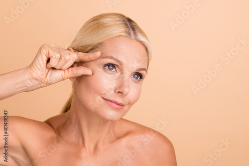 Close up photo of natural beauty aged model lady touch eyebrow line fingers look mirror isolated beige color background photo