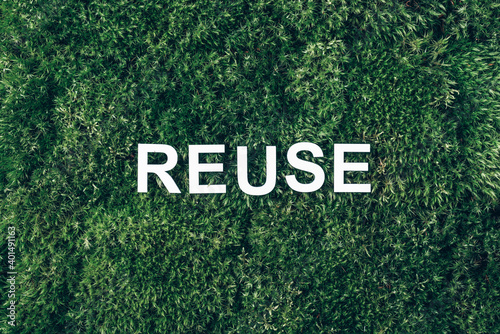 Word Reuse on moss, green grass background. Top view. Copy space. Banner. Biophilia concept. Nature backdrop
