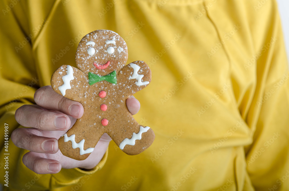 Boy holding gingerbread man in one hand