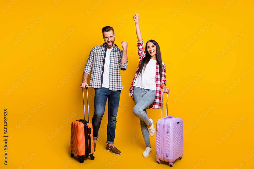 Photo portrait full body view of cheerful excited couple with suitcases isolated on vivid yellow colored background - obrazy, fototapety, plakaty 