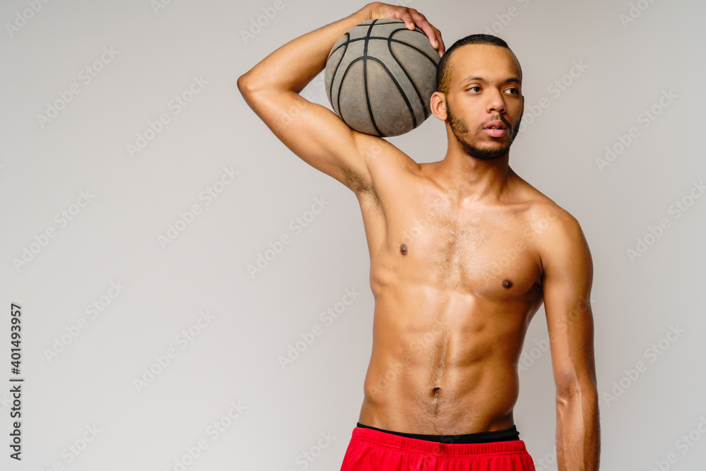 Muscular african american sportsman playing basketball shitless over light grey background Muscular african american sportsman playing basketball shitless over light grey background