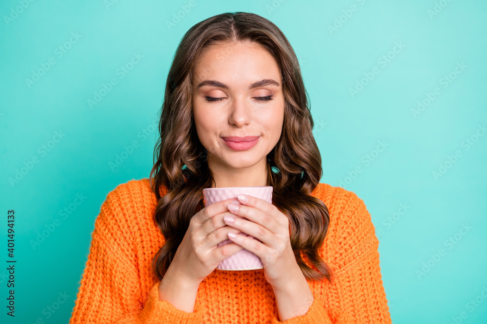 Portrait of young pretty lovely smiling girl smelling drinking tea coffee enjoying break time isolated on teal color background - obrazy, fototapety, plakaty 