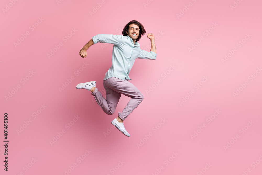 Full size profile side photo of excited cheerful man fump fly run wear violet trousers white shoes isolated on pink color background