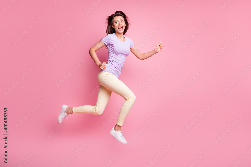 Full length body size profile side view of her she nice attractive glad cheerful cheery teen girl jumping having fun running marathon isolated over pink pastel color background Full length body size profile side view of her she nice attractive glad cheerful cheery teen girl jumping having fun running marathon isolated over pink pastel color background