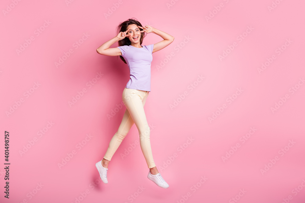 Full length body size view of her she nice-looking attractive lovely charming cheerful cheery thin girl jumping walking having fun showing double v-sign isolated over pink pastel color background Full length body size view of her she nice-looking attractive lovely charming cheerful cheery thin girl jumping walking having fun showing double v-sign isolated over pink pastel color background