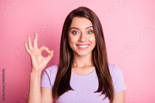 Photo portrait of funny cheerful girl showing okay sign gesture with fingers isolated on pastel pink color background