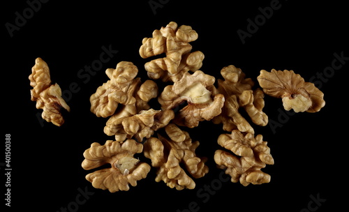 Unshelled walnuts pile isolated on black background with clipping path, top view