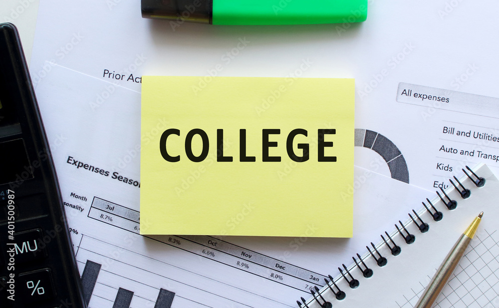 Obraz premium Text COLLEGE on the page of a notepad lying on financial charts on the office desk.
