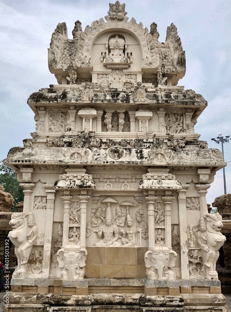 Temple tower against blue sky background. Ancient Hindu temple with sandstone carved historical Hindu God and animal sculptures.