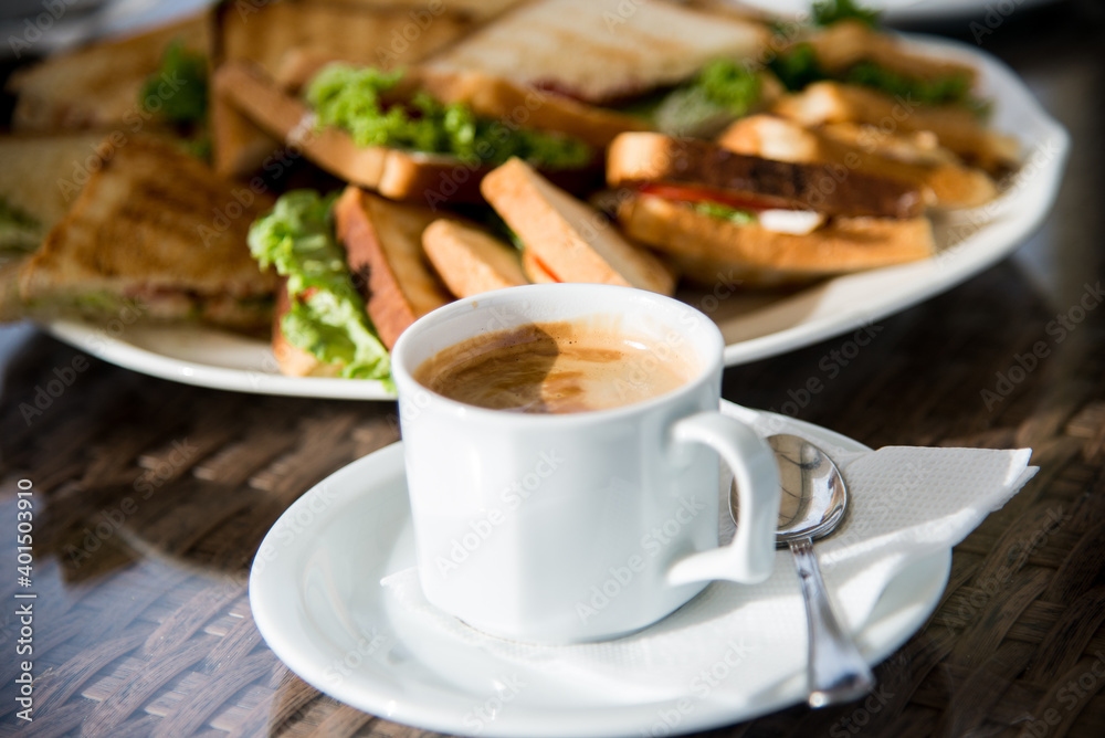 Sandwiches with chicken meat, cheese, cucumber, grilled toasts, and a cup of coffee. Sandwiches and coffee. Sandwiches with chicken meat, cheese, cucumber, grilled toasts, and a cup of coffee. Sandwiches and coffee.