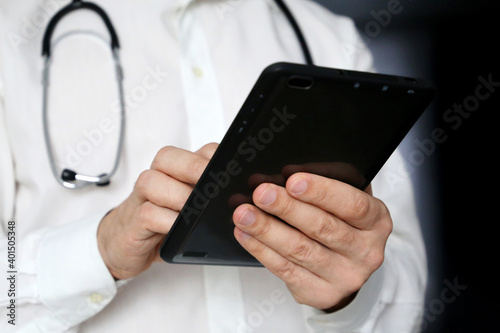 Doctor with a tablet PC in hands. Filling out the medical history