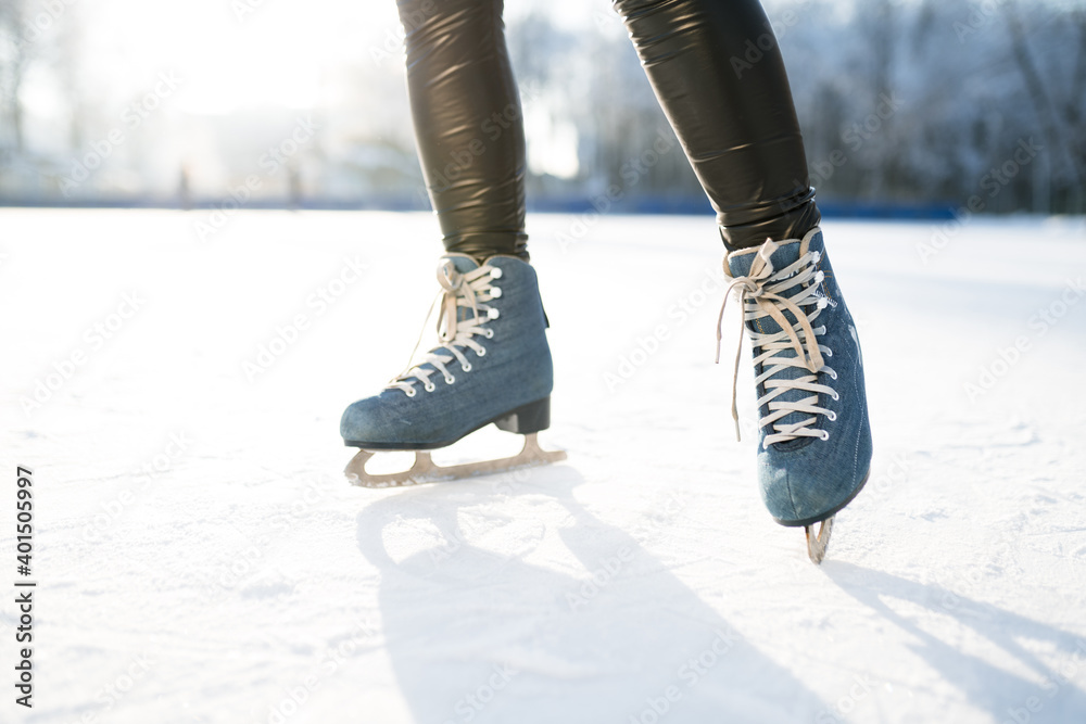 Photo of blue skates with white lacing against the background of sun glare in winter Photo of blue skates with white lacing against the background of sun glare in winter