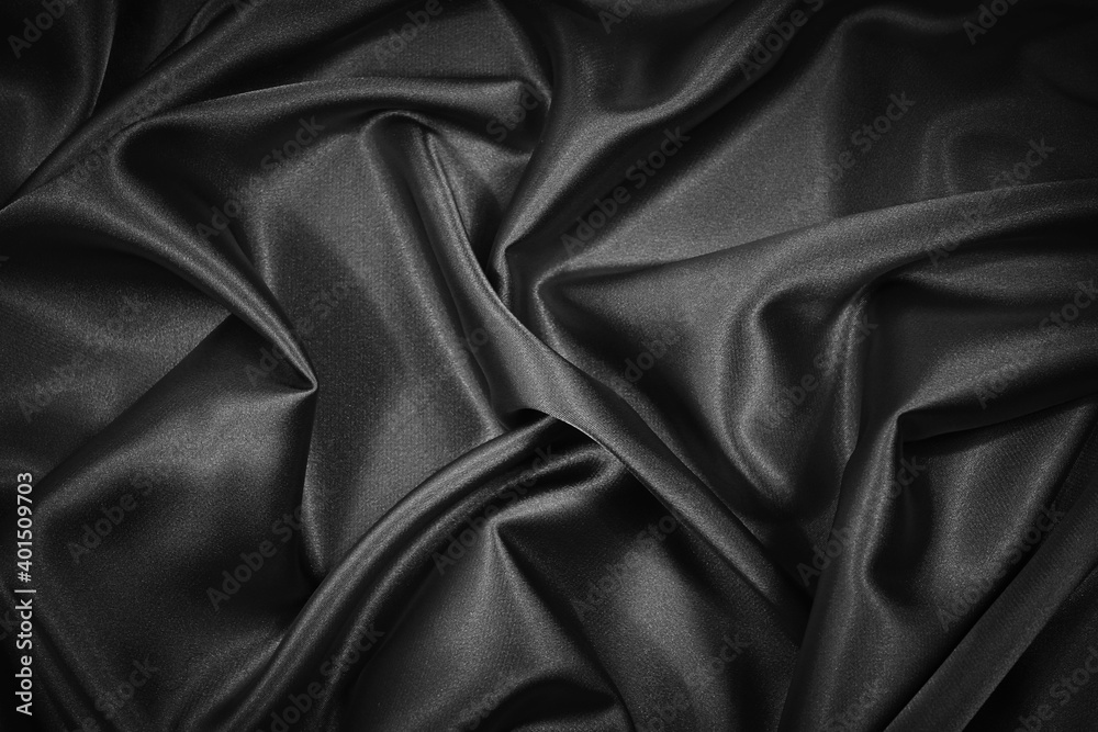 Abstract black background. Black silk satin fabric texture background.  Beautiful soft folds on shiny fabric. Black elegant background for your  design. Stock Photo