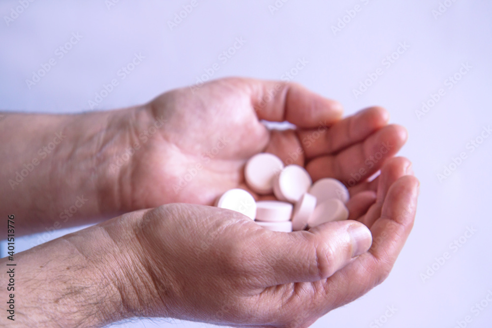 Beautiful men's hands with pills on a light background. Side view Beautiful men's hands with pills on a light background. Side view