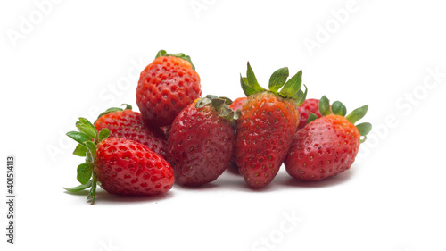 Close up view a group of fresh red strawberries with leaves on isolated white background.