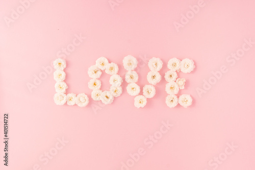 Flowers composition. The word LOVE is made of small white roses on a pink background,. Mother's day, Valentine's day, birthday, spring, summer concept. Flat lay, top view © Alena