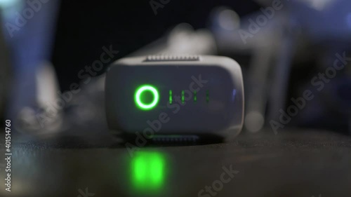 Исходный текст
The battery from the drone is being charged in close-up and the charge indicator is shown in neon green stripes across it.
