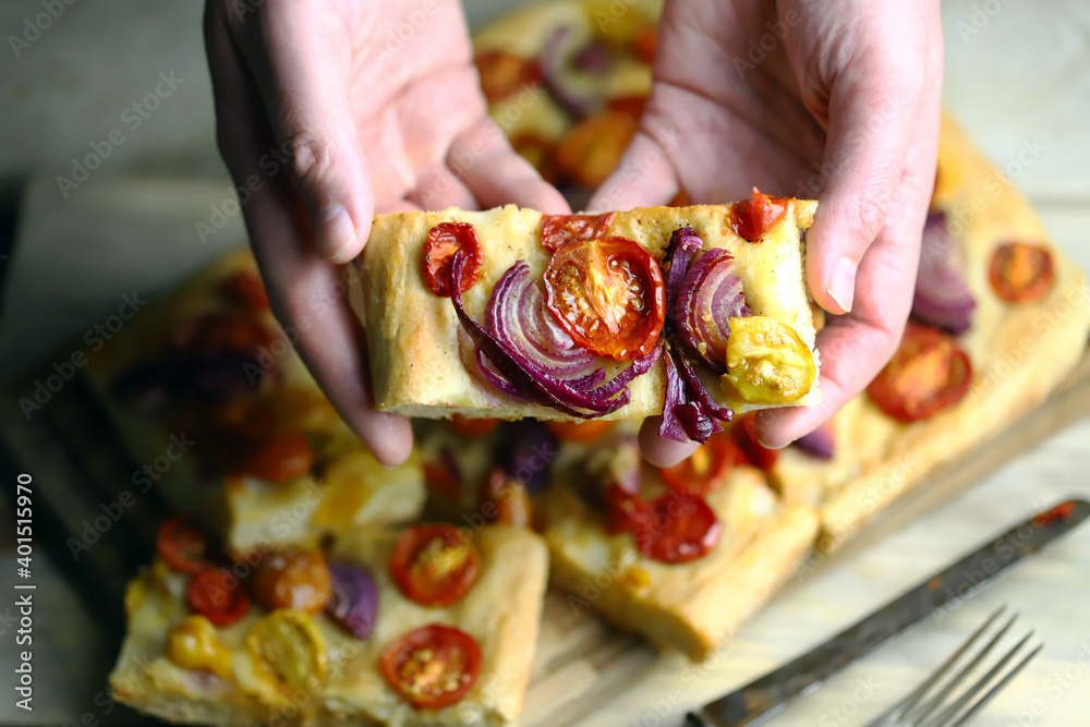 Fresh homemade focaccia with blue onions and cherry tomatoes.