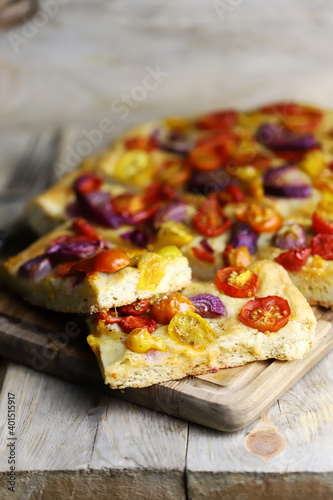 Fresh homemade focaccia with blue onions and cherry tomatoes.