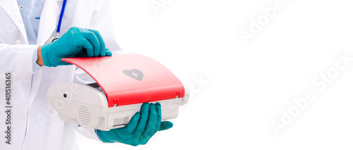 Doctor's hand wearing blue gloves Hold the AED Or defibrillator A red machine wearing a white coat stands obliquely on a white background A blue stethoscope