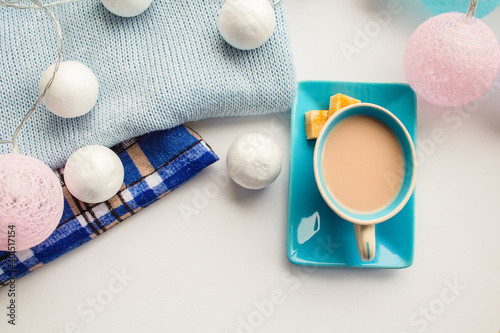 Coffee with milk in a blue set and cubes of cane sugar in the New Year scenery on blue textiles