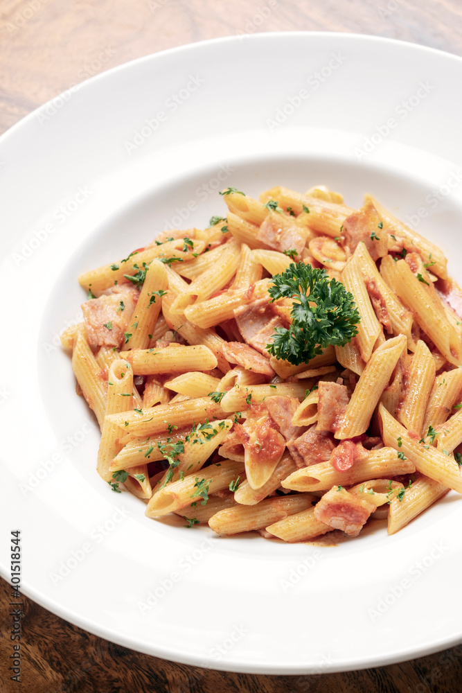penne amatriciana tomato and ham sauce pasta on wood table penne amatriciana tomato and ham sauce pasta on wood table