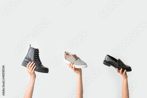 Hands with stylish shoes on white background photo