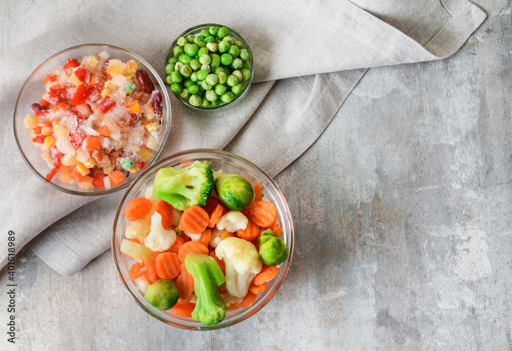 Frozen vegetables in bowls on light background Frozen vegetables in bowls on light background
