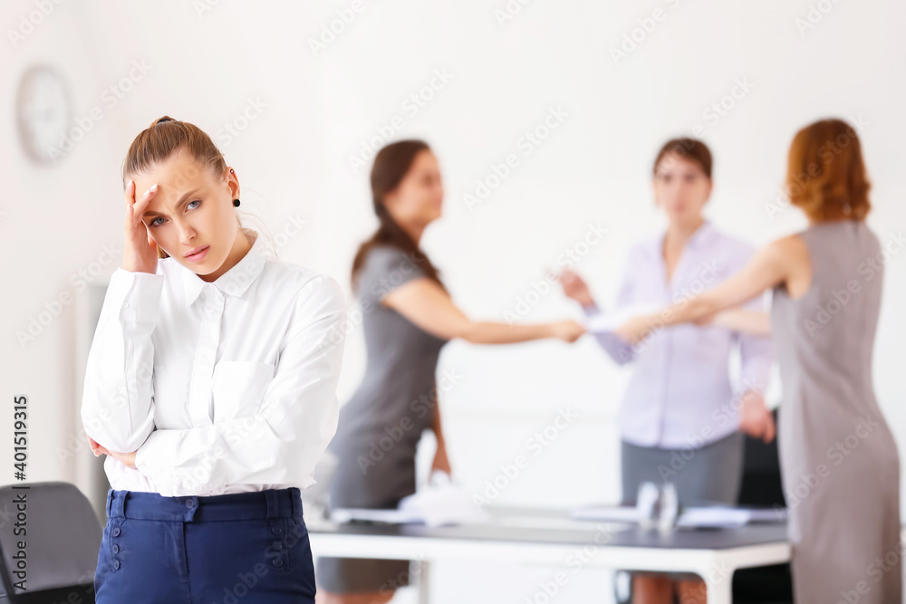 Stressed woman with headache and noisy people in office Stressed woman with headache and noisy people in office