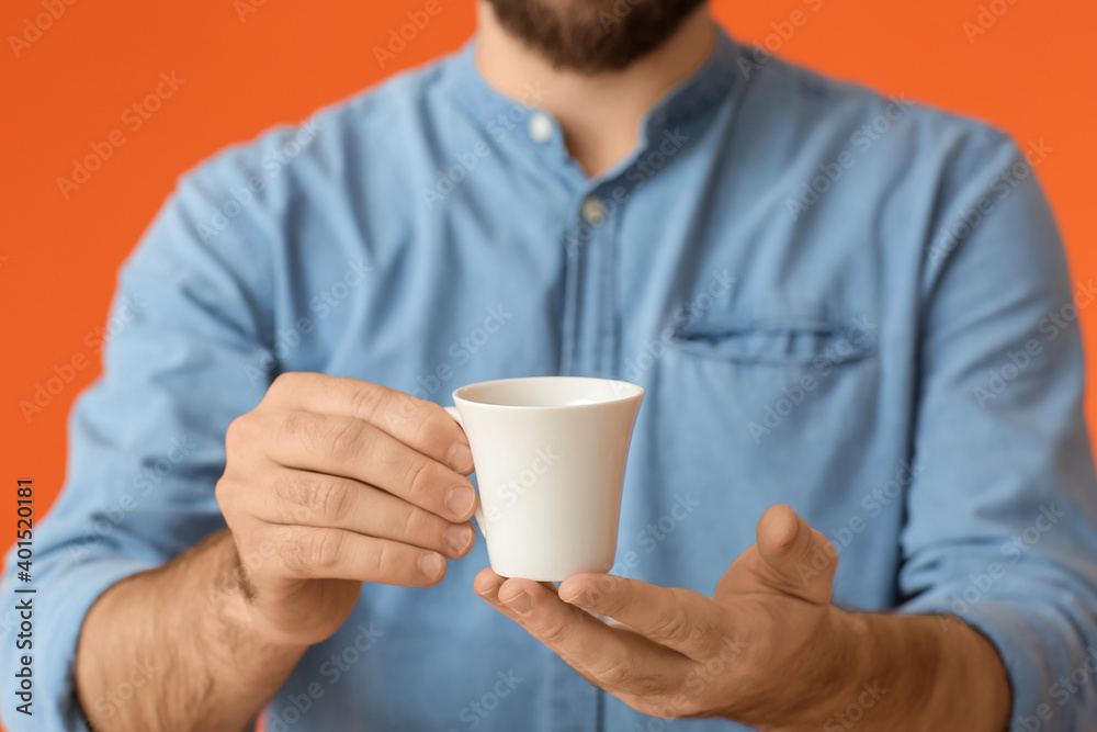 Young man with cup of hot coffee on color background, closeup Young man with cup of hot coffee on color background, closeup